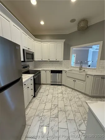 a kitchen with a sink a stove a refrigerator and cabinets