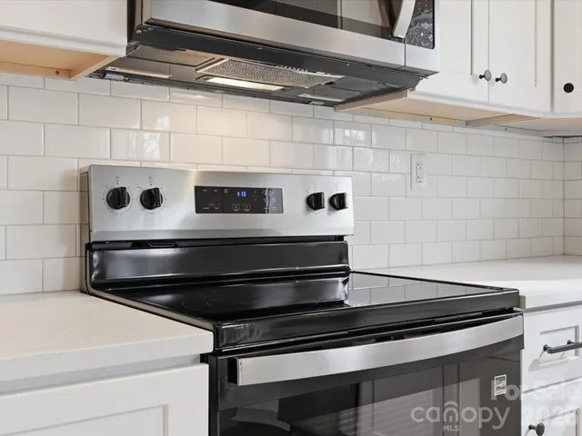 a stove top oven sitting inside of a kitchen