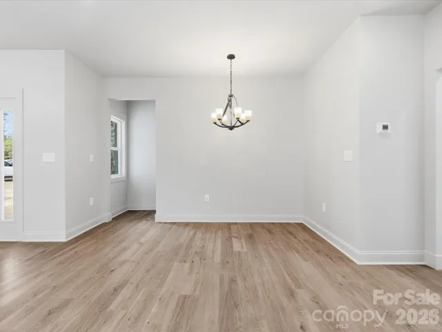 a view of a room with wooden floor and white walls
