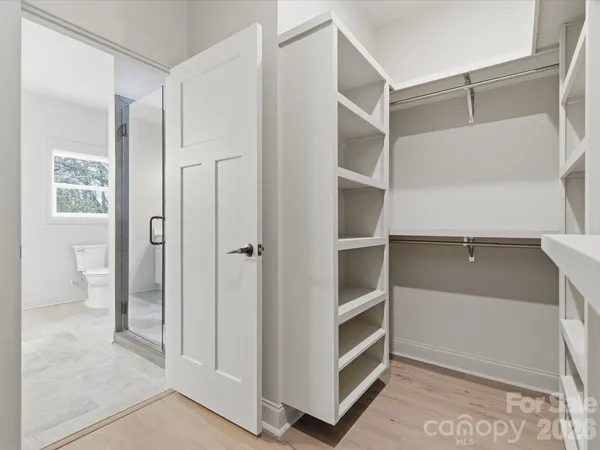 a view of walk in closet with empty racks