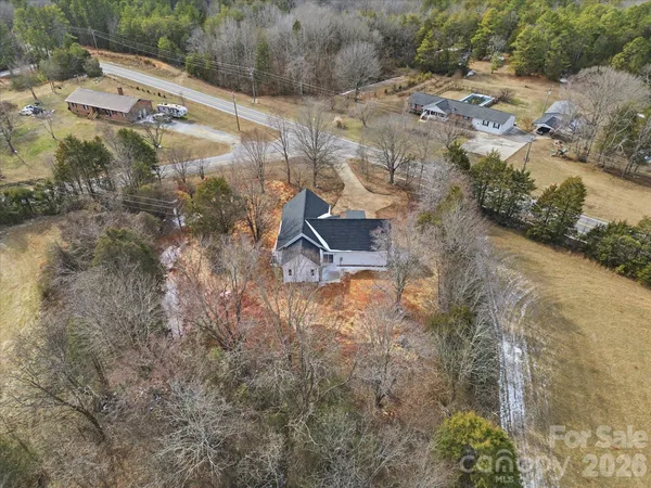 a aerial view of a house with a yard and lake view