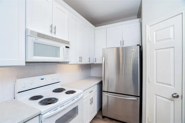 a kitchen with a refrigerator sink stove and cabinets