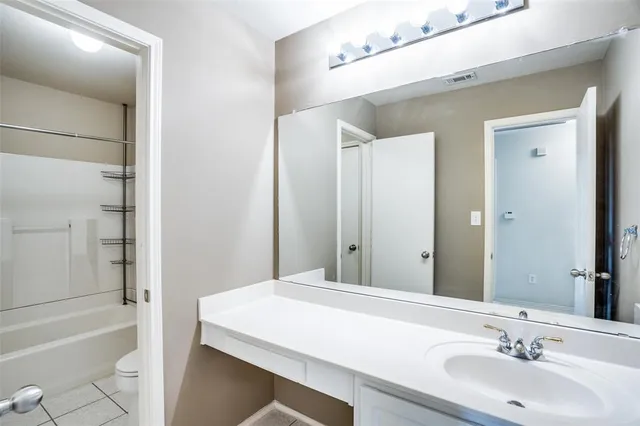 a bathroom with a sink a toilet a tub and shower