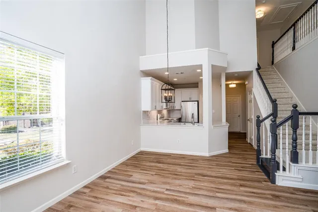 a view of entryway and kitchen with wooden floor