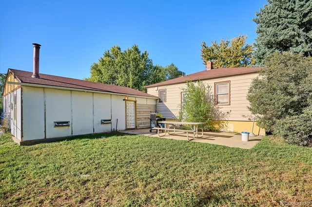 a backyard of a house with table and chairs