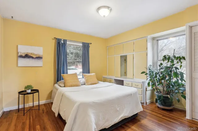 a bedroom with a large bed and a potted plant