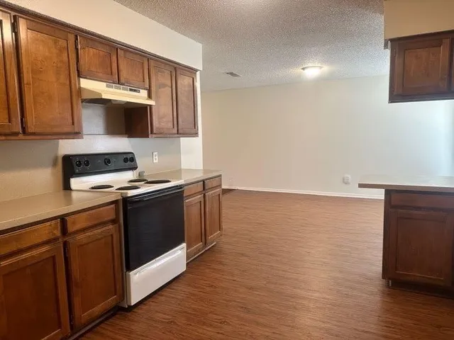 a kitchen with stainless steel appliances granite countertop a stove a sink and a microwave