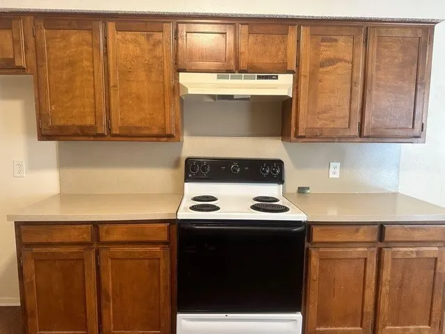 a kitchen with stainless steel appliances a stove a sink and a cabinets
