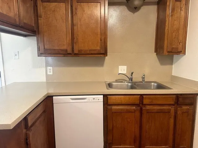 a kitchen with stainless steel appliances granite countertop white cabinets and a sink