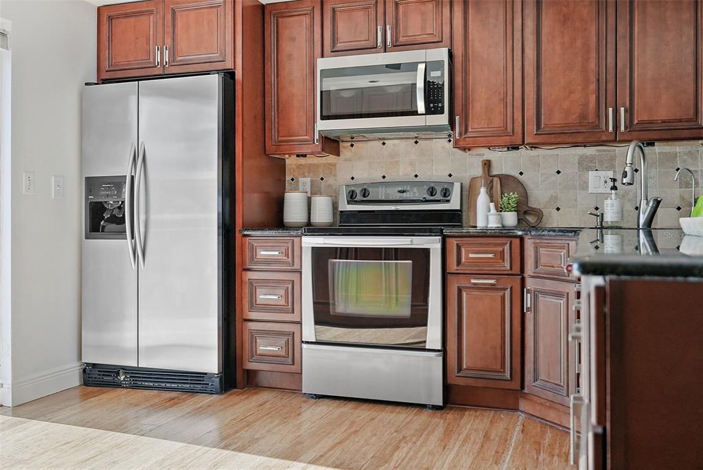 936 Pinellas Bayway South, Unit T5 Tierra Verde, FL 33715 - Photo 11 of 38 a kitchen with stainless steel appliances granite countertop a refrigerator stove top oven and sink