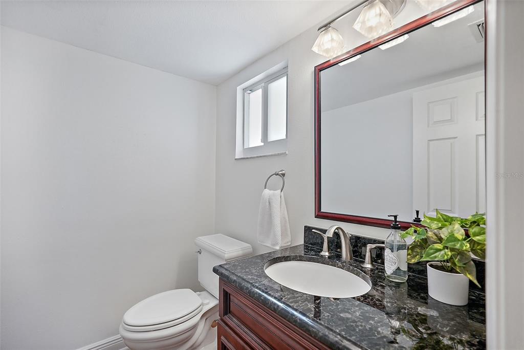 936 Pinellas Bayway South, Unit T5 Tierra Verde, FL 33715 - Photo 21 of 38 a bathroom with a granite countertop toilet a sink and a mirror