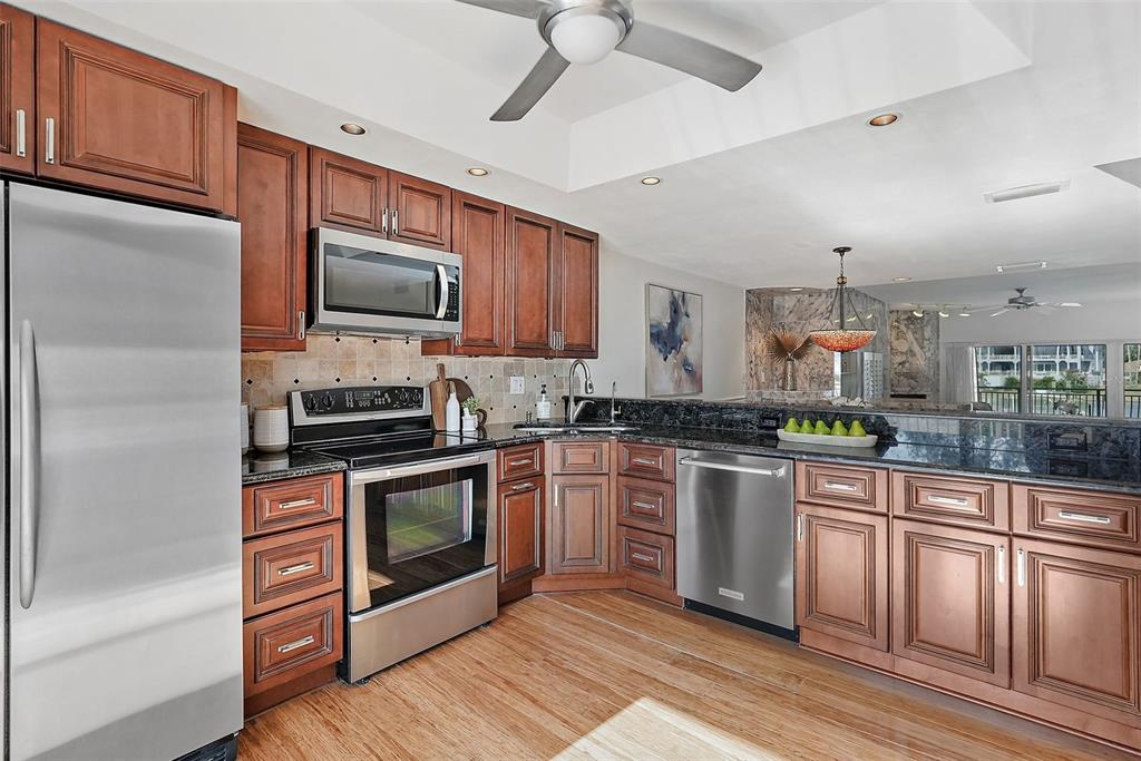 936 Pinellas Bayway South, Unit T5 Tierra Verde, FL 33715 - Photo 10 of 38 a kitchen with stainless steel appliances granite countertop a refrigerator a stove top oven a sink and dishwasher