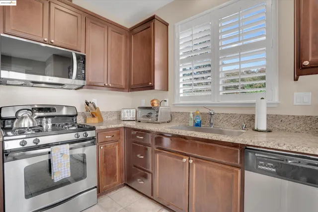 a kitchen with stainless steel appliances granite countertop white cabinets a microwave oven and a sink