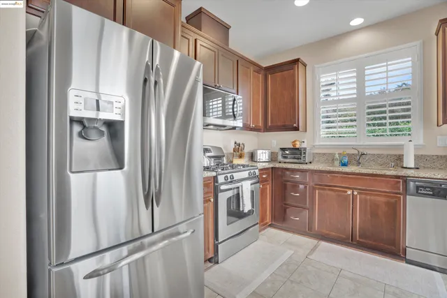 a kitchen with stainless steel appliances granite countertop a refrigerator sink and microwave