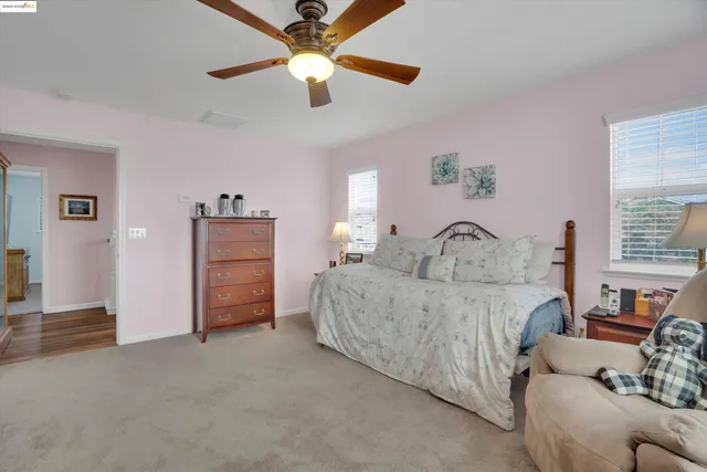 a living room with furniture and a ceiling fan