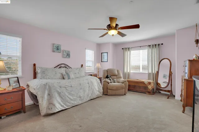 a spacious bedroom with a bed couch and a window