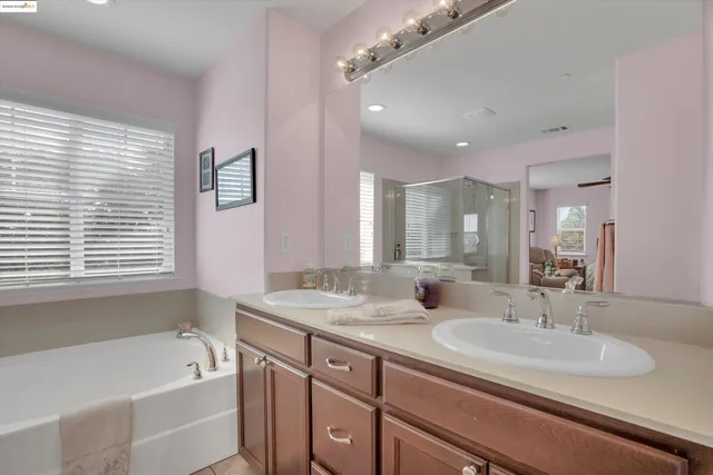 a bathroom with a granite countertop sink mirror and a bathtub