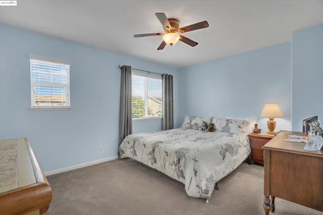 a bedroom with a bed painting on wall and a window