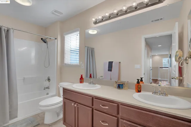a bathroom with a double vanity sink toilet mirror and bathtub
