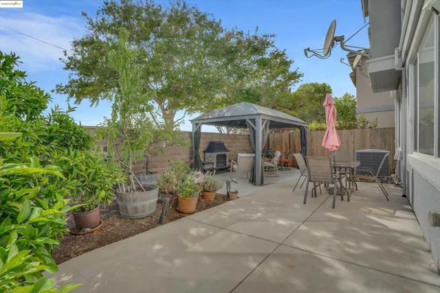 a view of a patio with a dining table and chairs under an umbrella