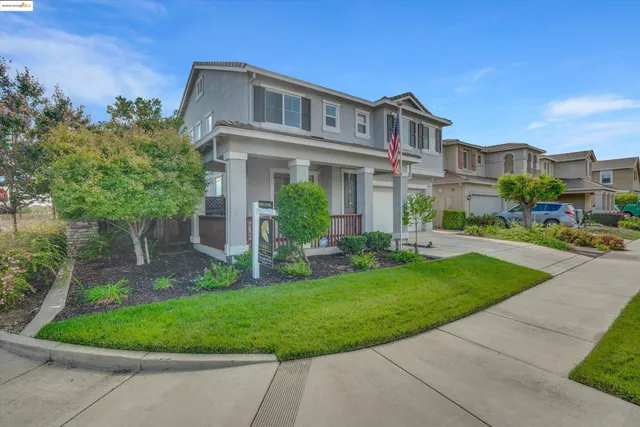 a front view of a house with a yard and trees
