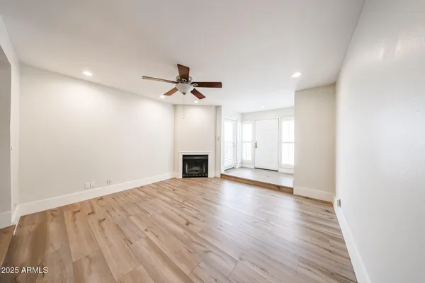 a view of empty room with wooden floor and fireplace