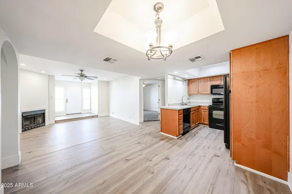 a view of kitchen with granite countertop stainless steel appliances and wooden floor
