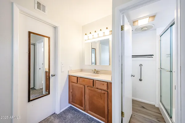 a bathroom with a granite countertop sink vanity and mirror