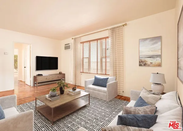 a living room with furniture a rug and a flat screen tv