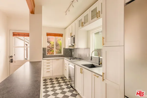 a kitchen with a sink a stove cabinets and a window