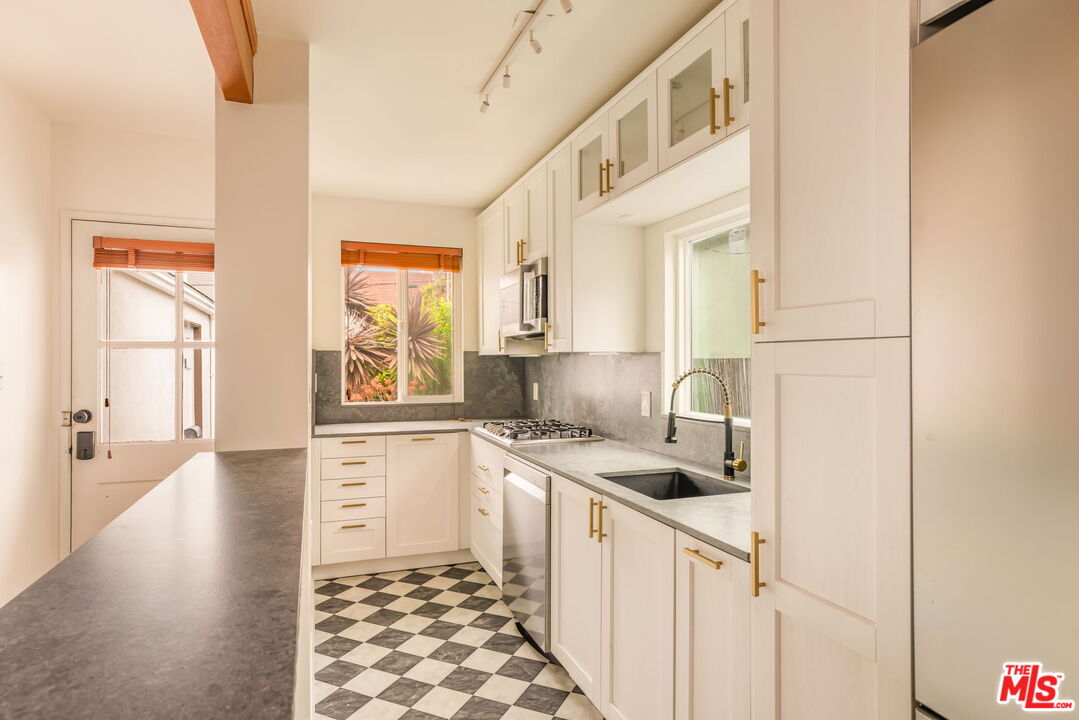 4332 Alla Road Los Angeles, CA 90066 - Photo 8 of 25 a kitchen with a sink a stove cabinets and a window