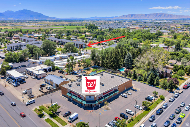 572 South 100 West, Unit E210 Springville, UT 84663 - Photo 29 of 35 Aerial perspective showcasing a commercial property with a large parking area, green awning features, and clear street frontage