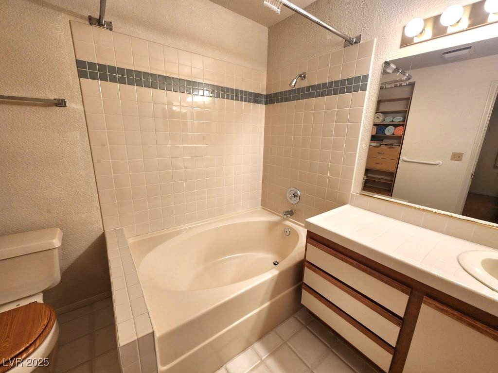 1964 Las Palmas Lane, Unit 141 Laughlin, NV 89029 - Photo 7 of 12 Full bathroom with a textured wall, toilet, tile patterned flooring, and shower / bath combination