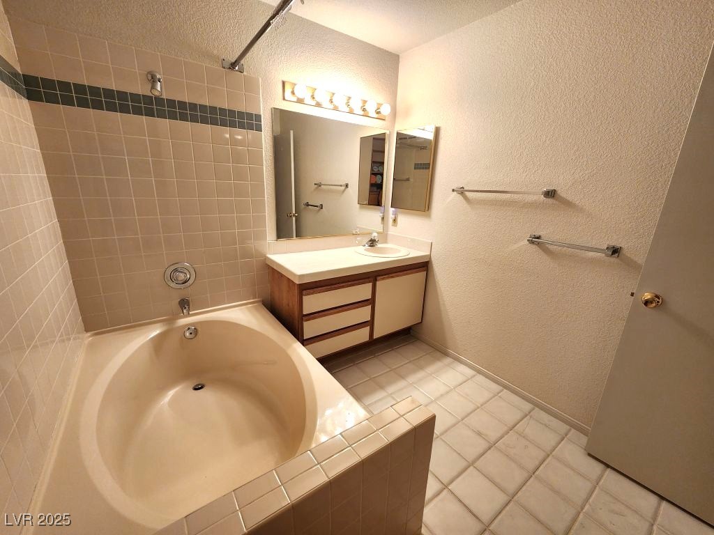 1964 Las Palmas Lane, Unit 141 Laughlin, NV 89029 - Photo 8 of 12 Bathroom with shower combination, a textured ceiling, a textured wall, and vanity