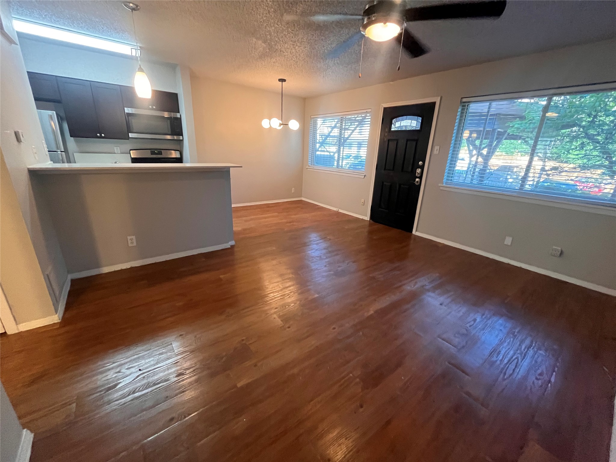 1202 Newning Avenue, Unit 207 Austin, TX 78704 - Photo 2 of 17 an open kitchen with kitchen island wooden floors and stainless steel appliances