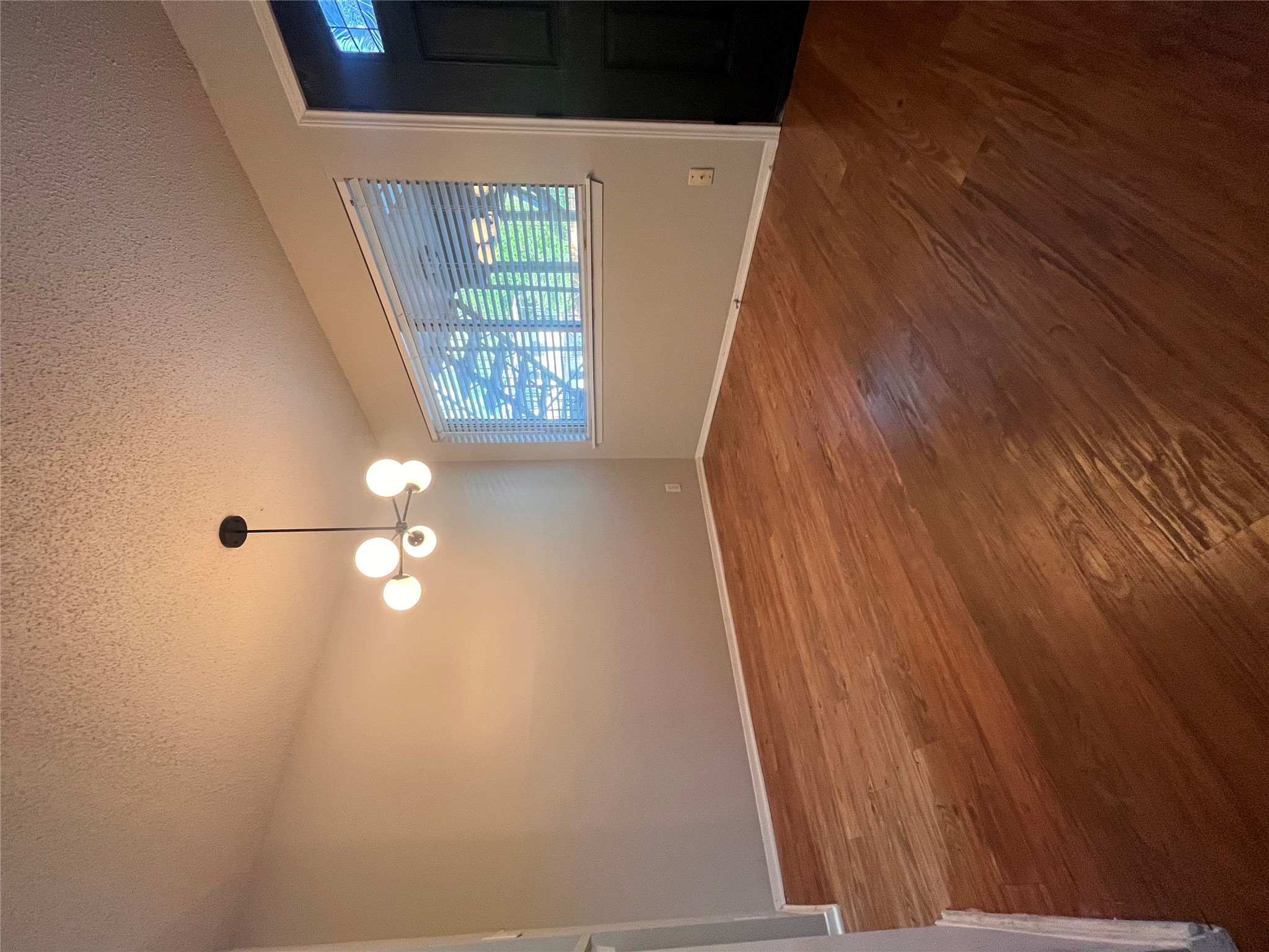 1202 Newning Avenue, Unit 207 Austin, TX 78704 - Photo 3 of 17 an empty room with wooden floor chandelier and windows