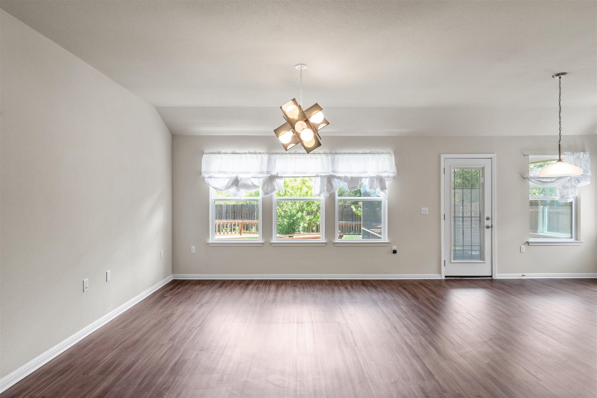 16512 Enamorado Road Manor, TX 78653 - Photo 7 of 31 Rich hardwood floors welcome you into this light-filled open concept living area.