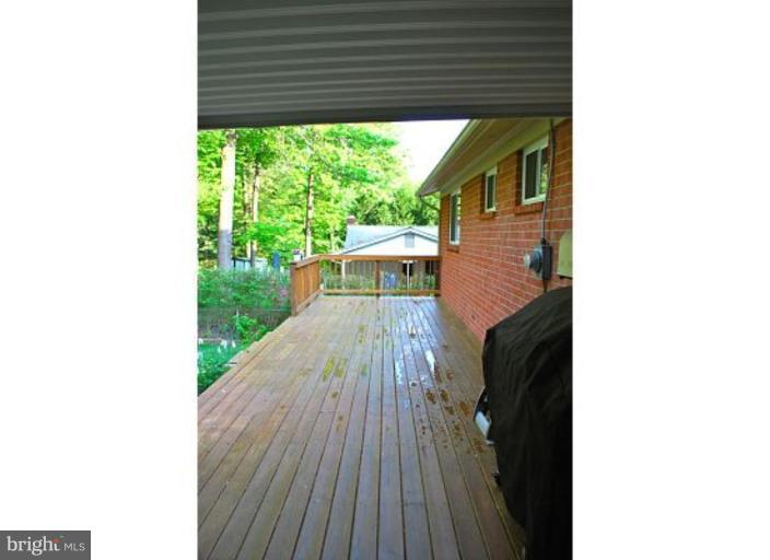 5529 Callander Drive Springfield, VA 22151 - Photo 23 of 30 a view of a patio with table and chairs with wooden floor and fence