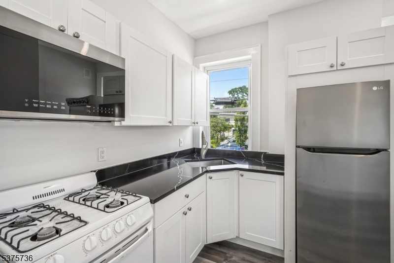 34 Main Street Millburn, NJ 07041 - Photo 13 of 23 a kitchen with a sink a stove and a refrigerator