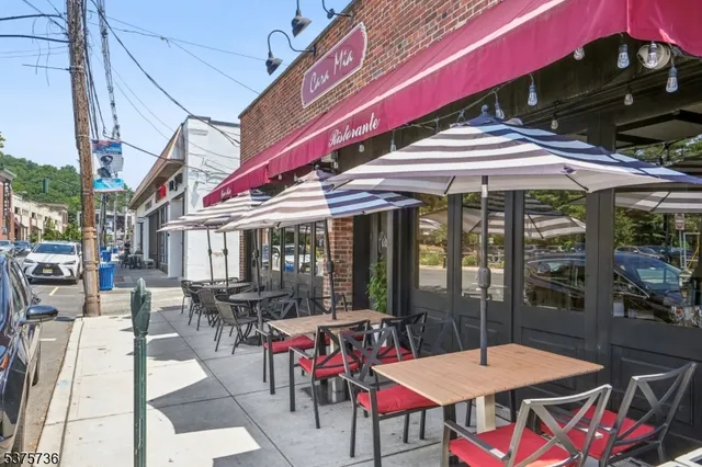a view of a patio with table and chairs potted plants and large tree