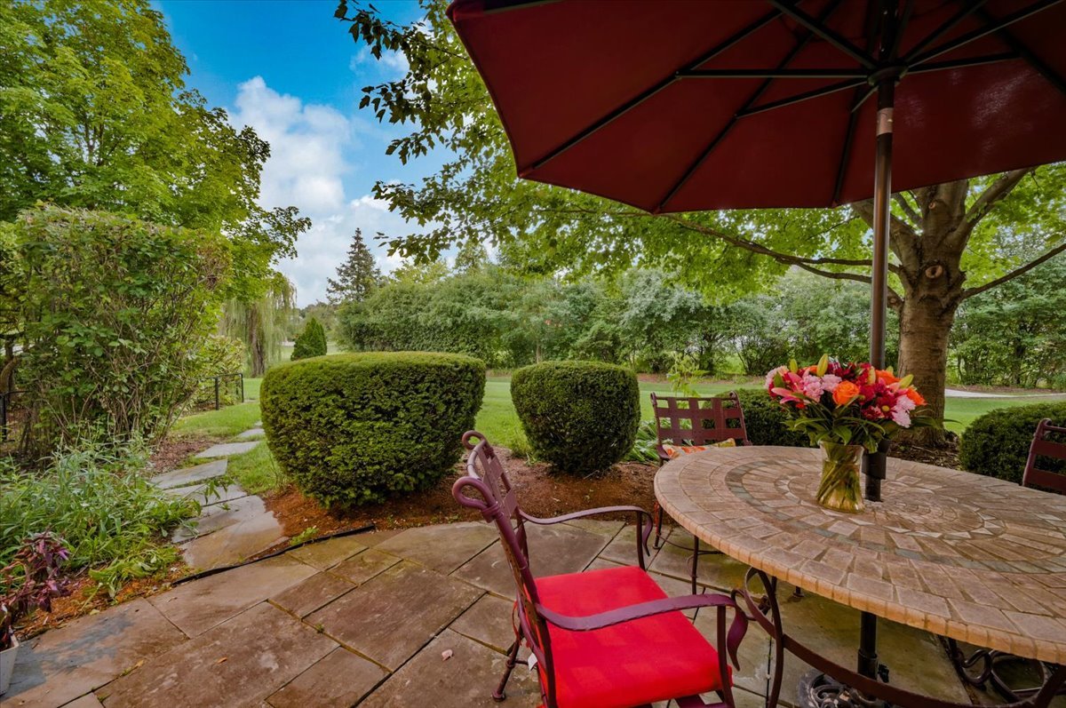 8010 Greenbriar Court Burr Ridge, IL 60527 - Photo 46 of 57 a view of a patio with table and chairs under an umbrella