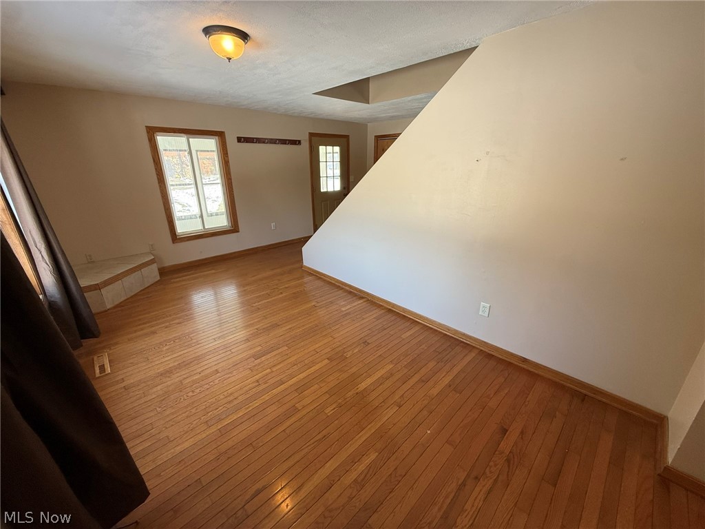 6784 Old Zoarville Road Northeast Dover, OH 44622 - Photo 7 of 50 Unfurnished living room featuring light wood finished floors and baseboards