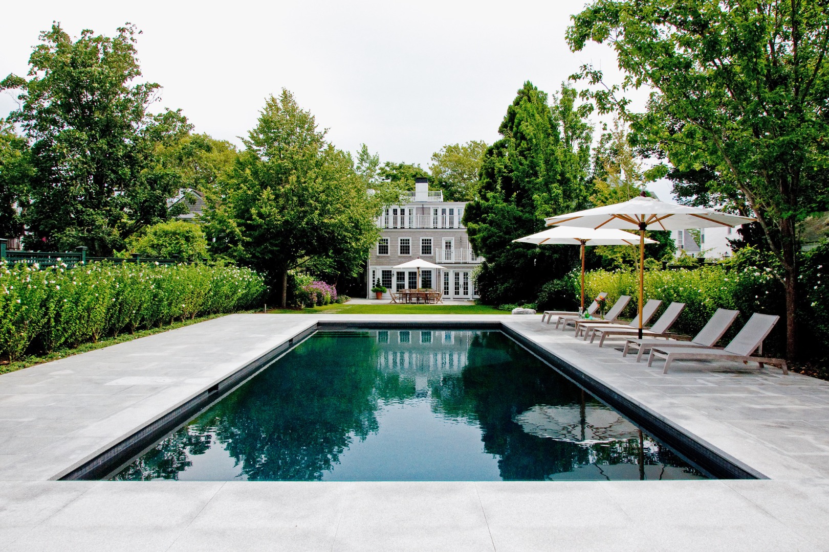 a swimming pool view with a seating space and a garden view