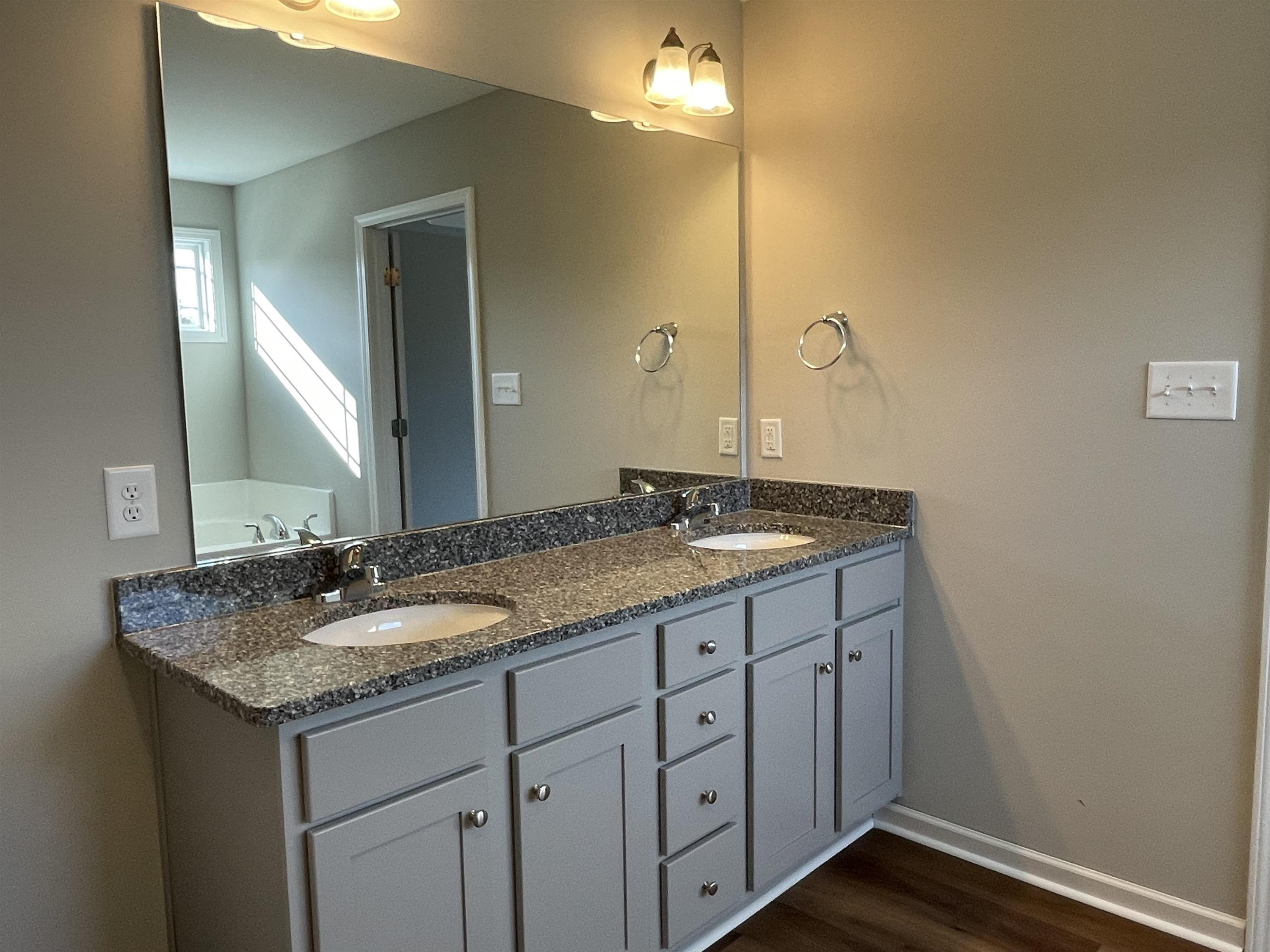 394 Touchdown Way Benson, NC 27504 - Photo 11 of 20 a bathroom with a granite countertop sink and a mirror