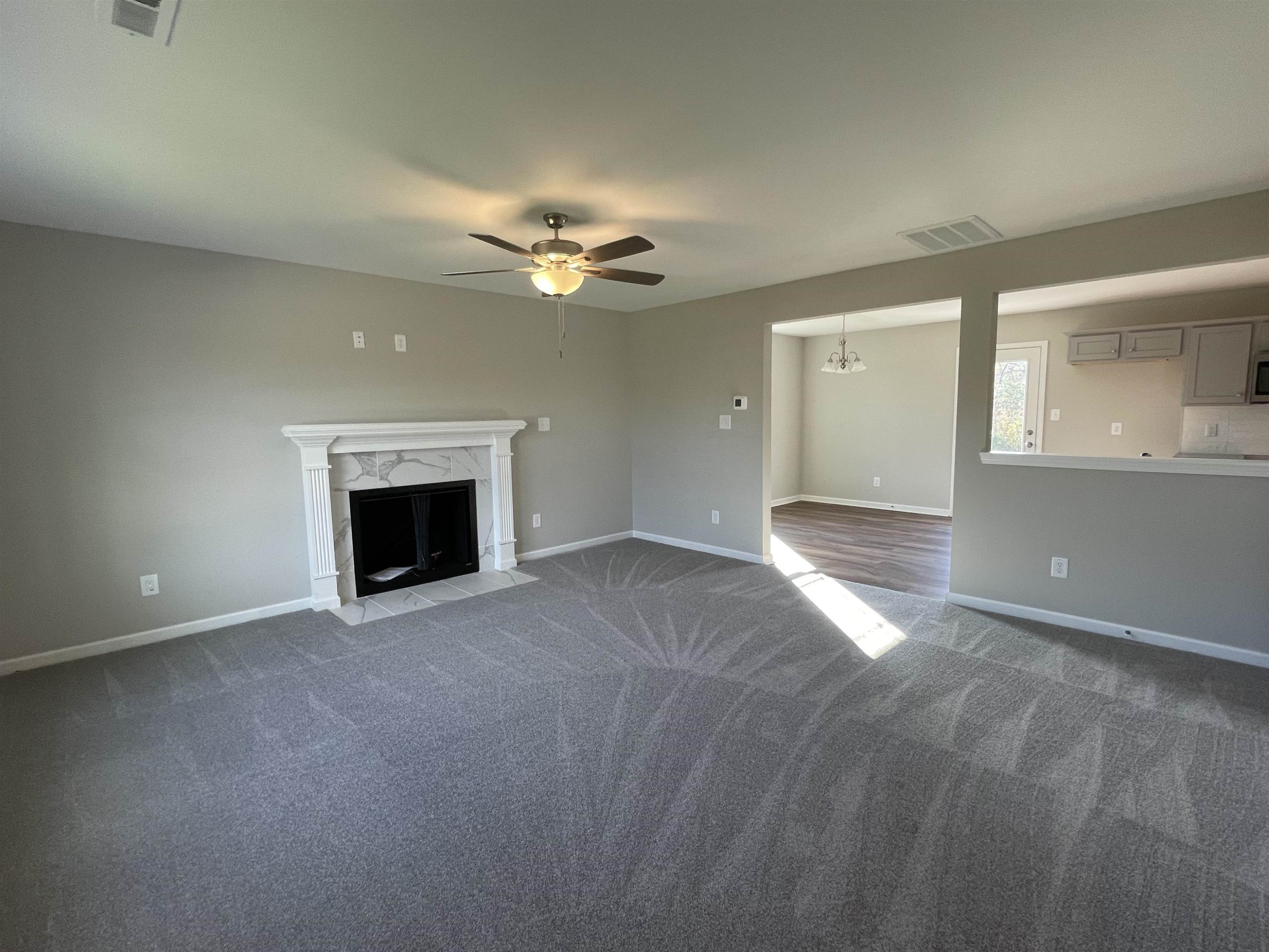 394 Touchdown Way Benson, NC 27504 - Photo 2 of 20 an empty room with a fireplace and fan