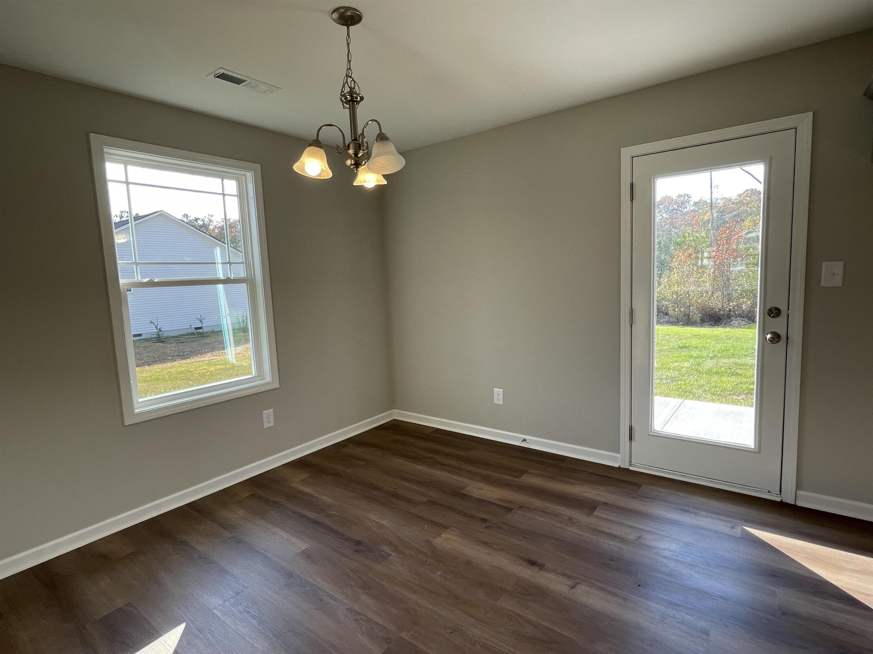 394 Touchdown Way Benson, NC 27504 - Photo 4 of 20 a view of an empty room with wooden floor and a window