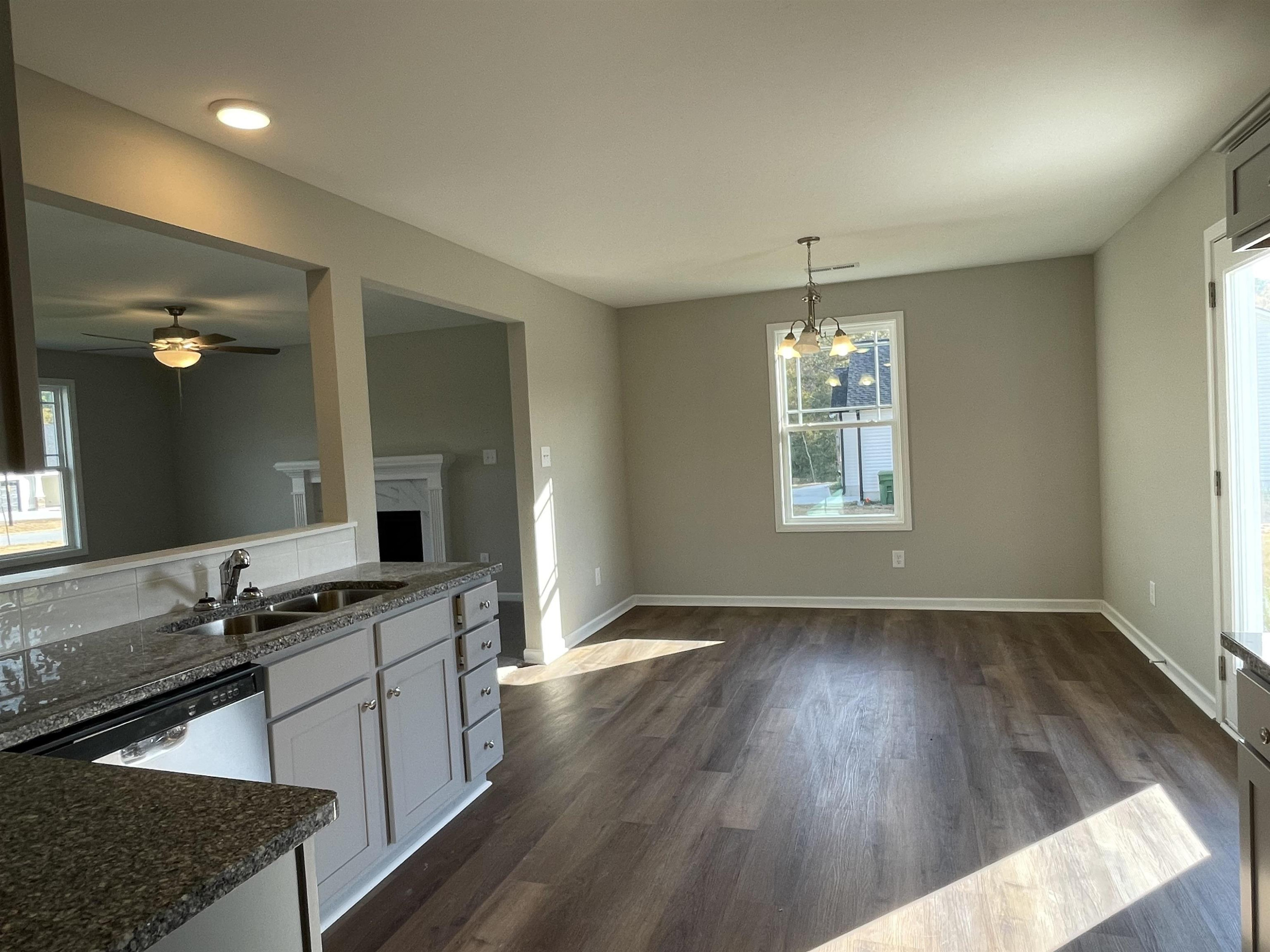 394 Touchdown Way Benson, NC 27504 - Photo 5 of 20 a kitchen with granite countertop a stove a sink and a refrigerator