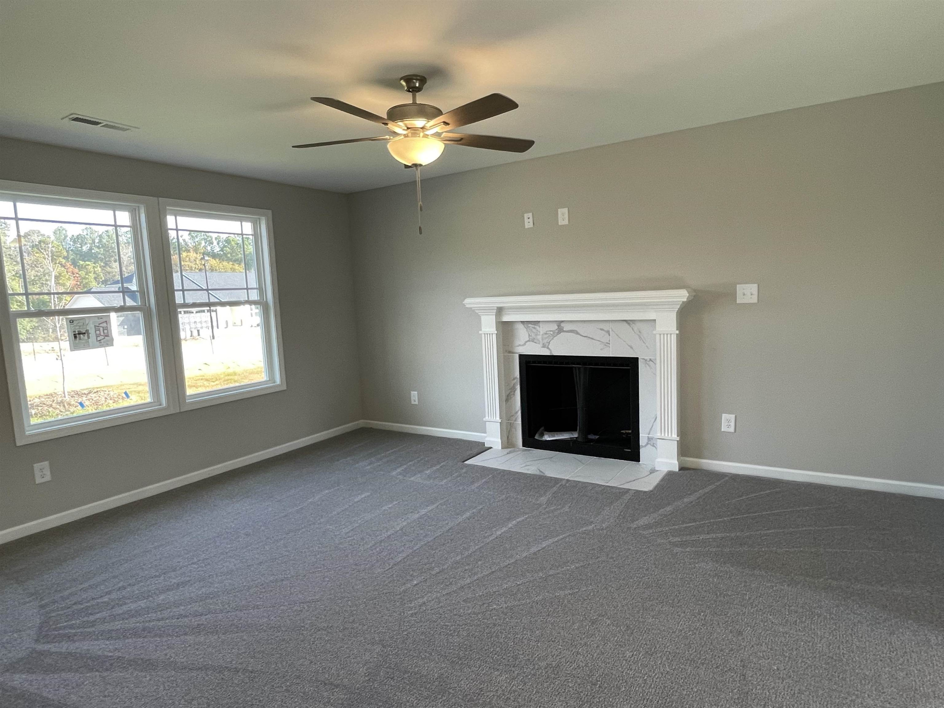 394 Touchdown Way Benson, NC 27504 - Photo 6 of 20 an empty room with fan and windows