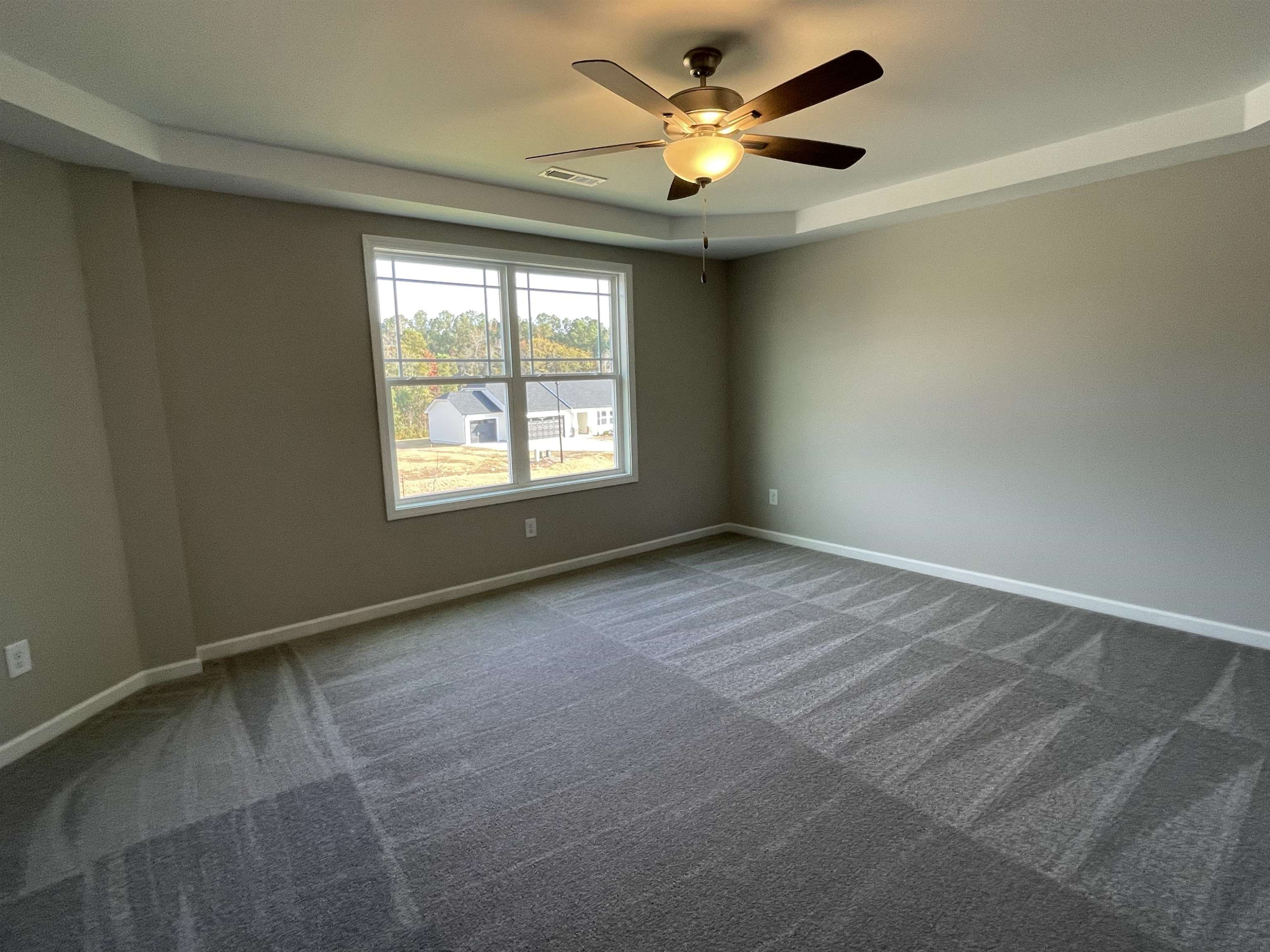 394 Touchdown Way Benson, NC 27504 - Photo 9 of 20 an empty room with a window and a fan