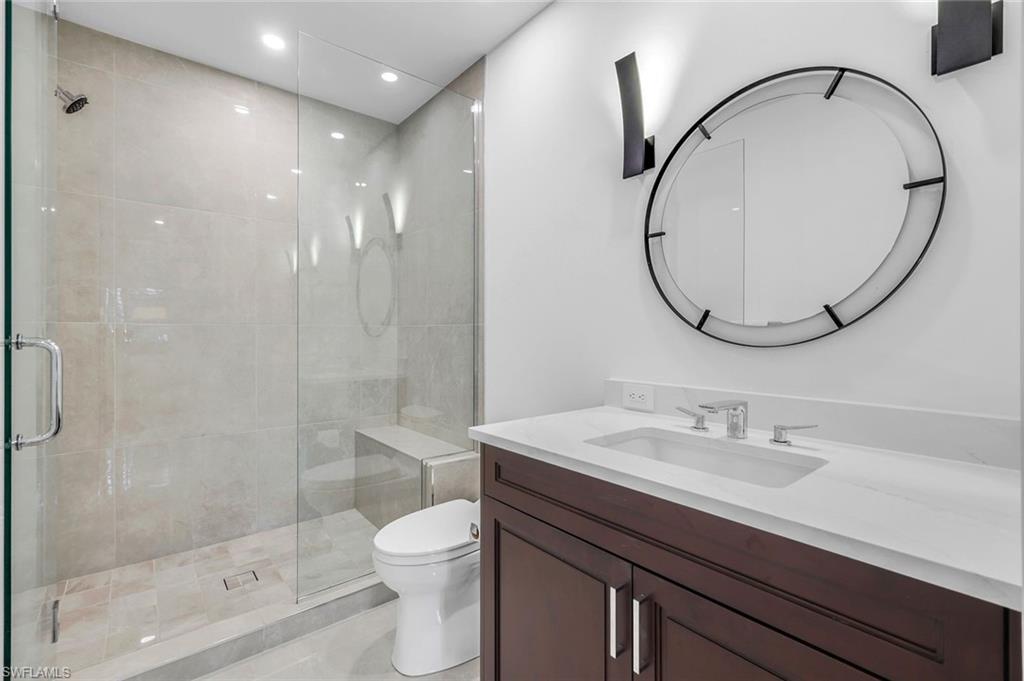 1130 3rd Avenue South, Unit 115 Naples, FL 34102 - Photo 14 of 28 a bathroom with a sink a toilet and a mirror